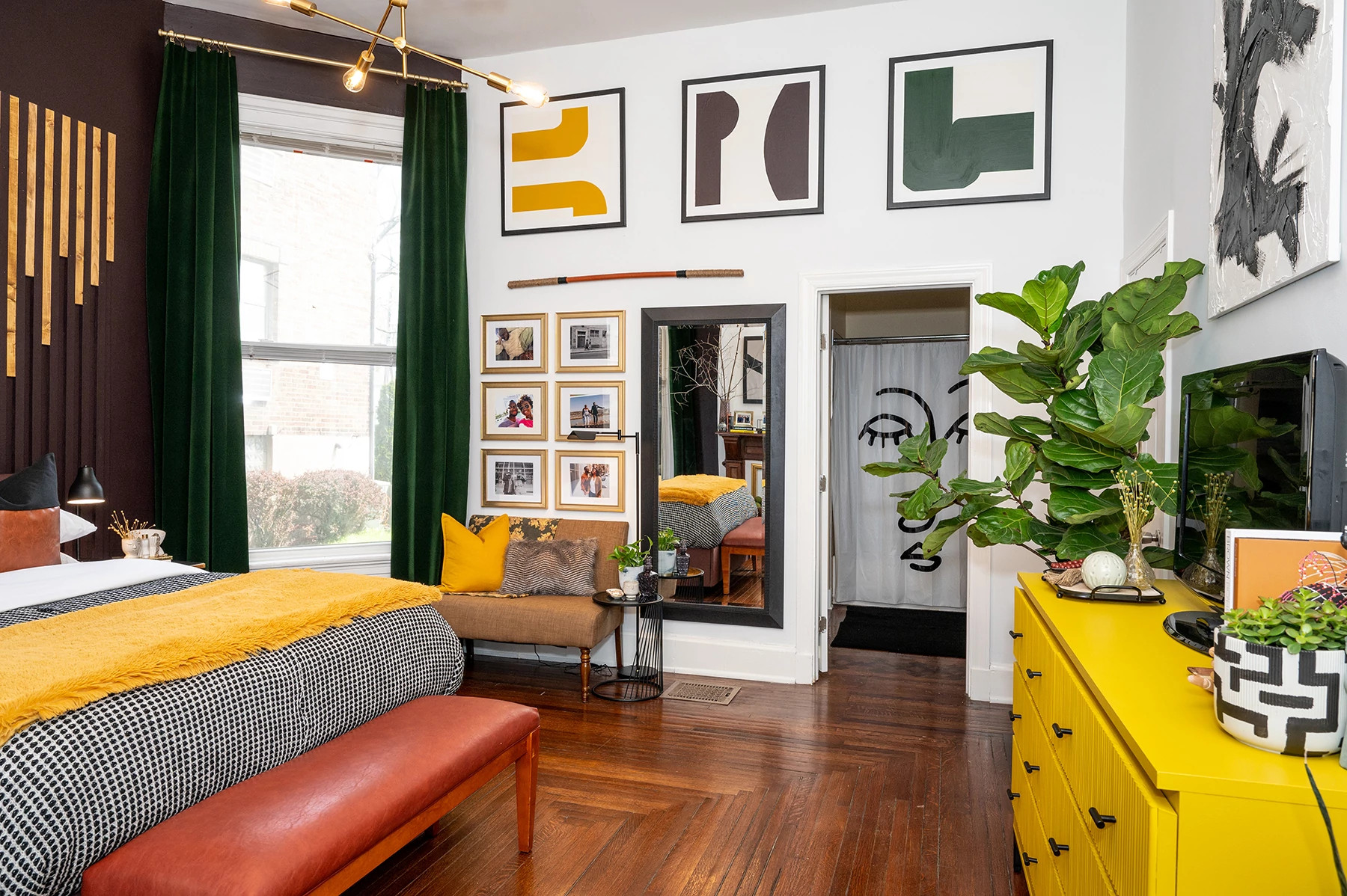 Modern living room with a DIY gallery wall, family photos, and orange leather bench