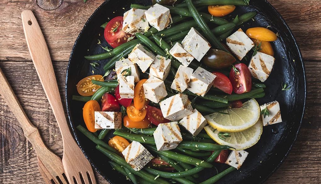 Extra protein may make the dish more filling and bring you important nutrients A close-up view of a green bean salad with grilled tofu in a bowl