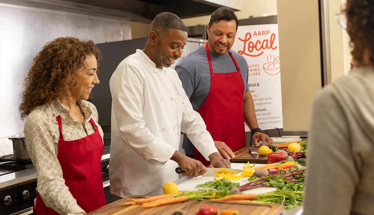 AARP Local cooking class where chef is chopping up ingredients while engaging with participants