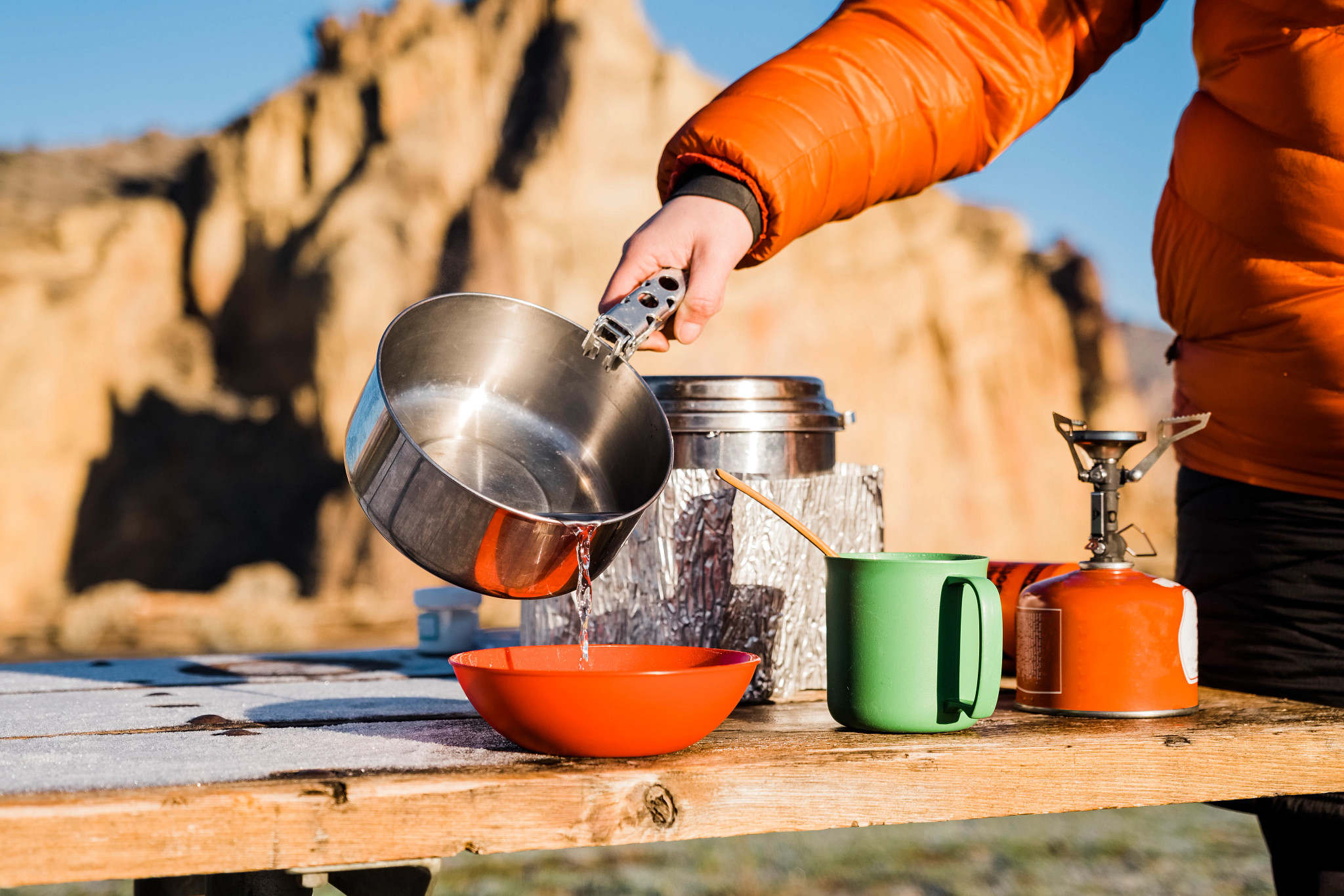 a person pouring water from a pot into a bowl at a camspite