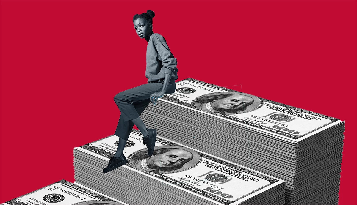 Photo illustration of a person sitting on large stacks of hundred-dollar bills against a bright red background
