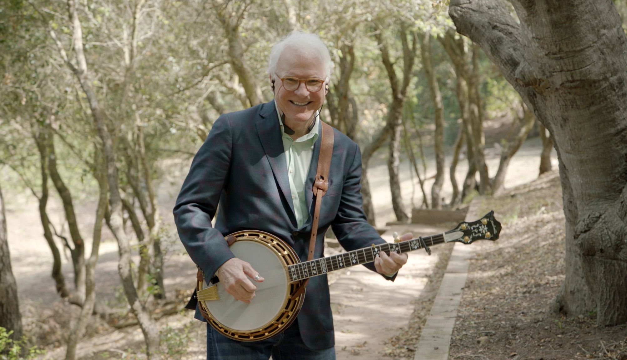 Steve Martin’s Wild and Crazy Life Lessons steve martin smiling while playing a banjo in the woods