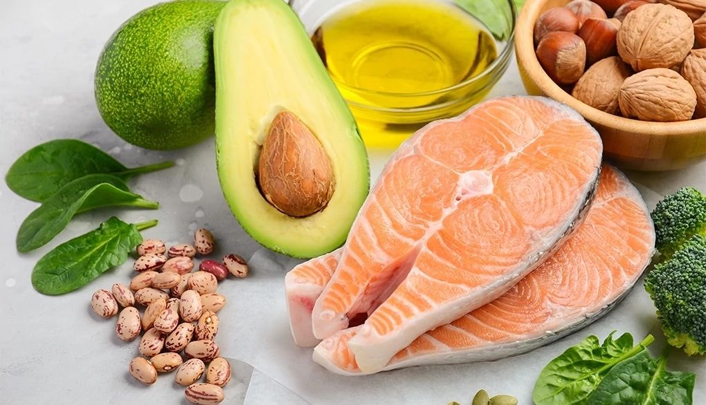 Omega-3 fatty acids in fish may provide brain benefits A close-up view of salmon, beans, avocado, olive oil, spinach, broccoli and mixed nuts