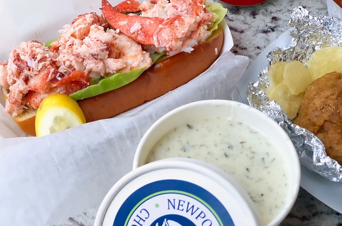 Great Seafood Dives a bowl of clam chowder next to lobster meat and other food