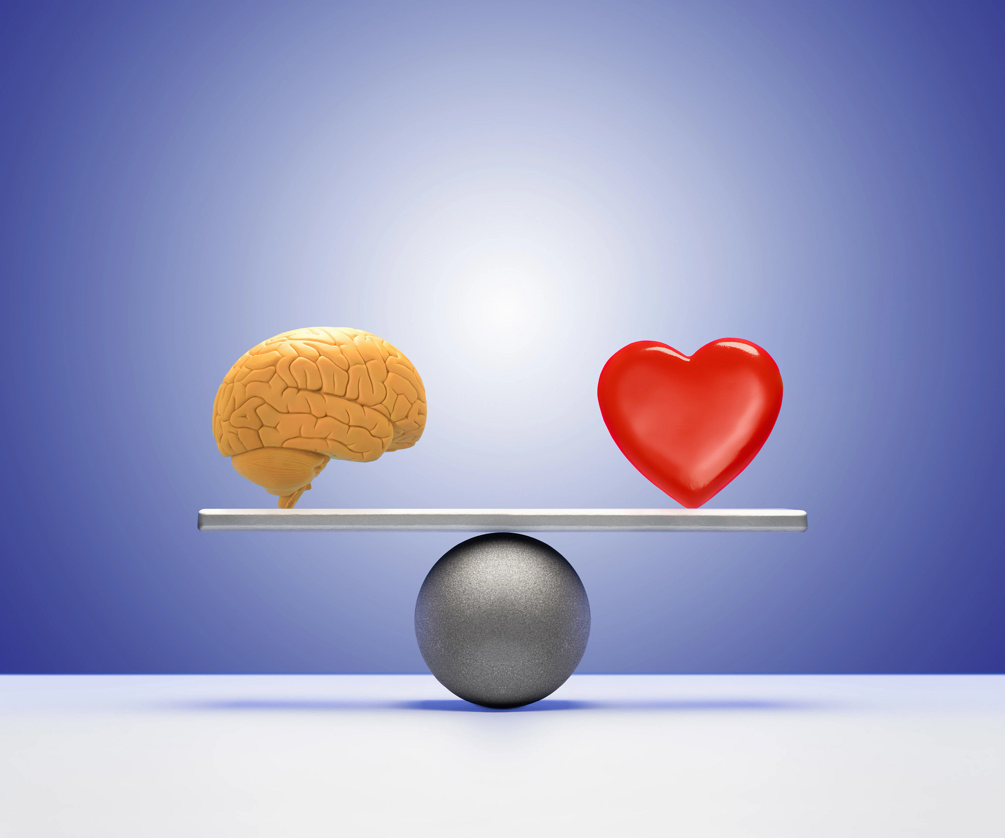 An illustration of a heart and brain balancing on a seesaw scale