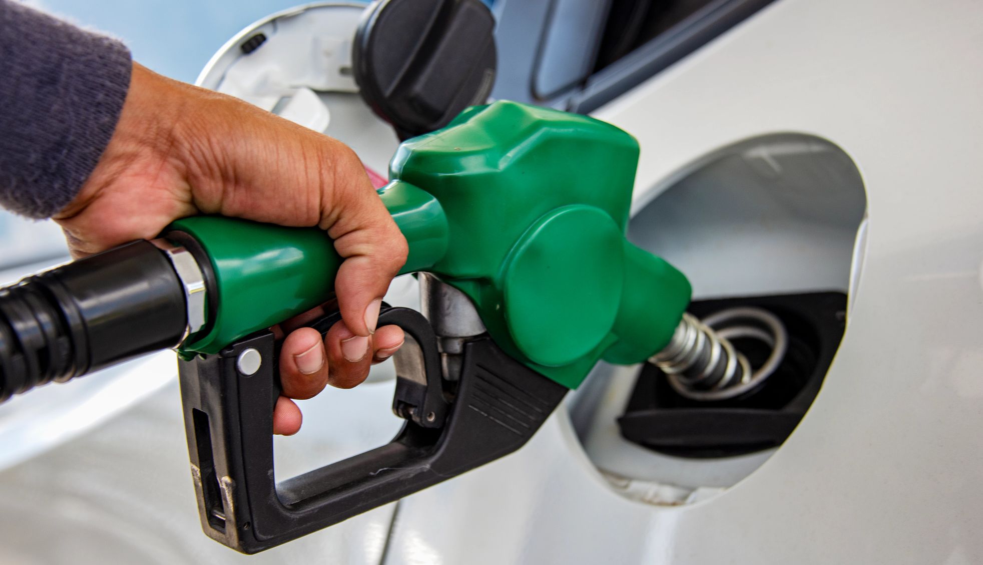 Why Is Gas So Cheap Right Now? a person getting gas