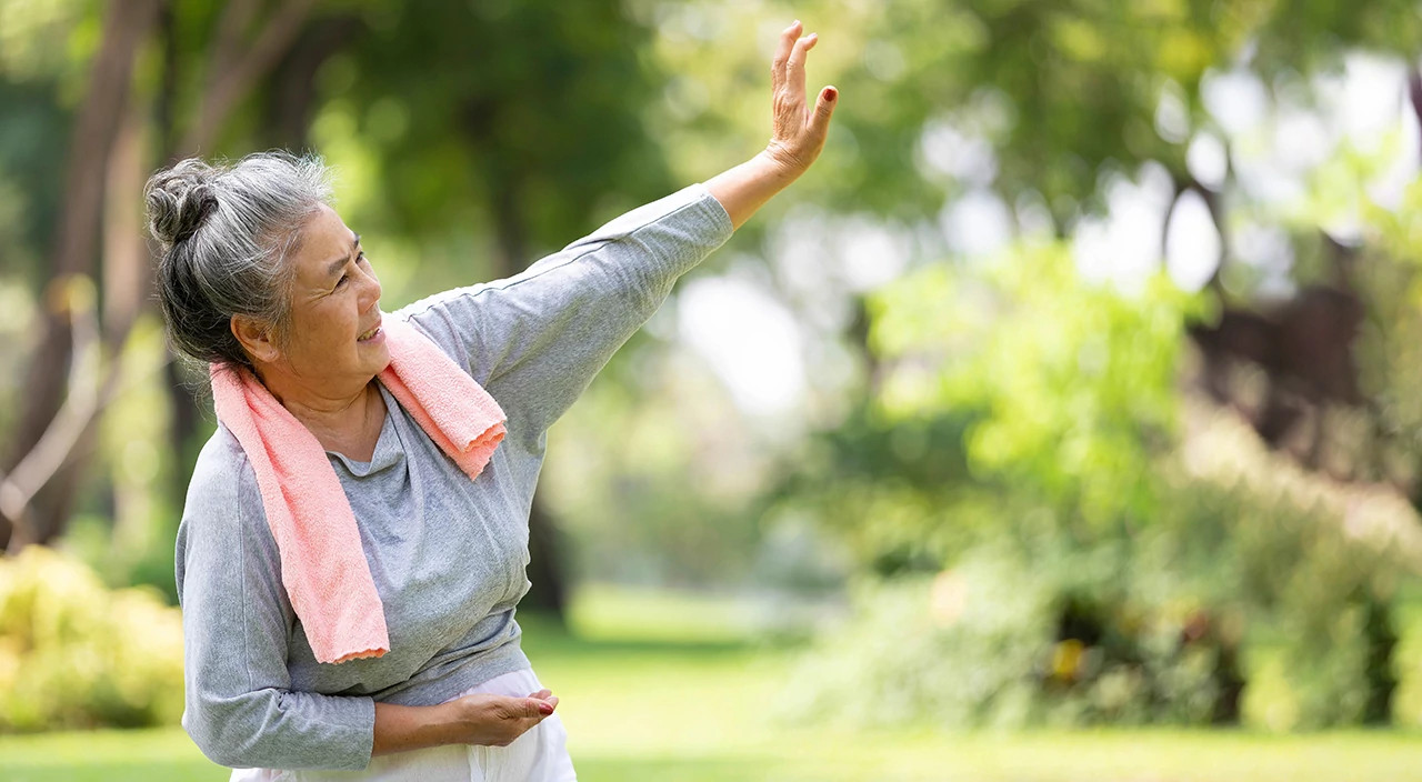 Mature woman doing tai chi outside on a nice day