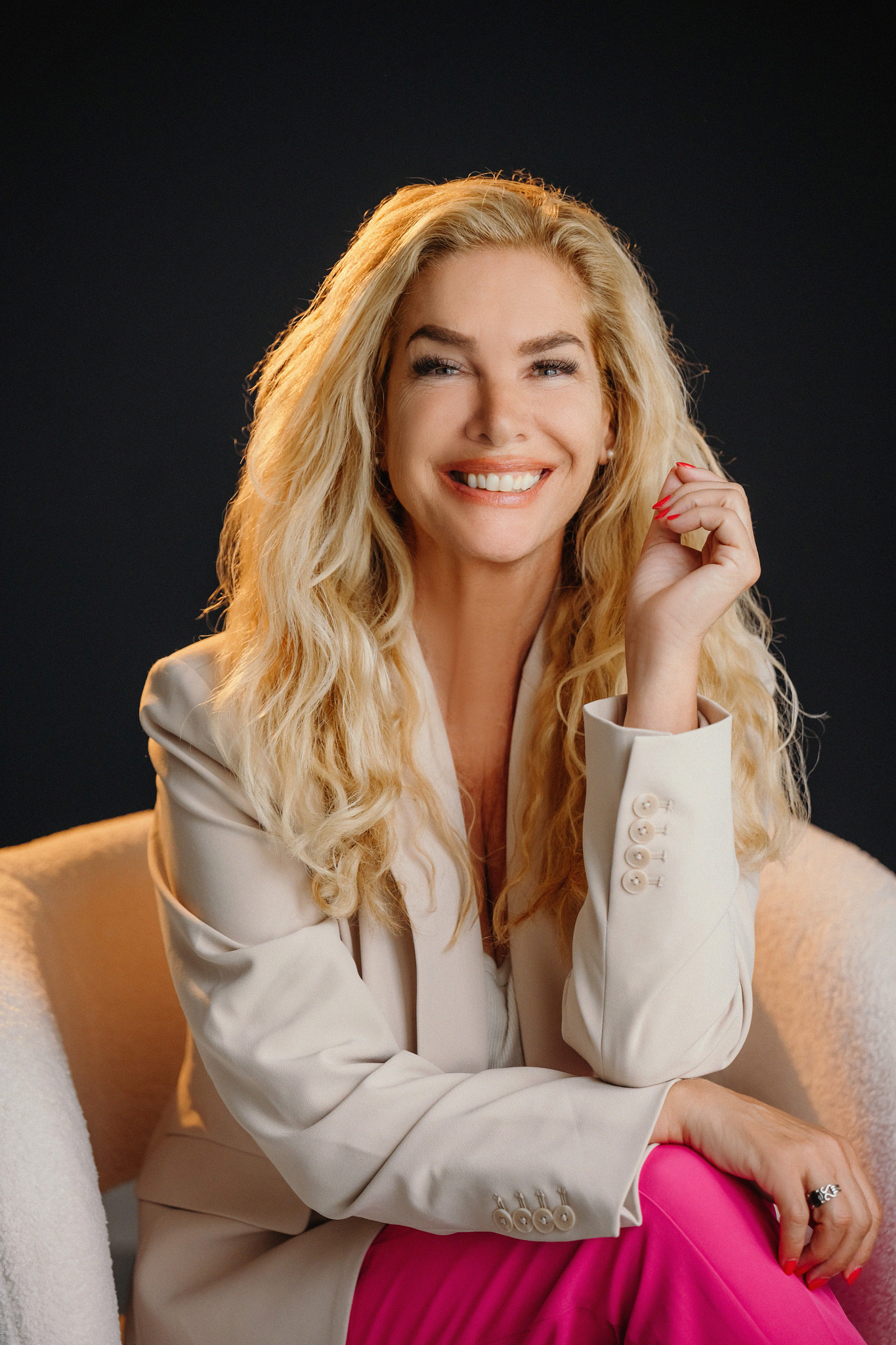 suzanne o'brien sits in a chair and smiles at the camera