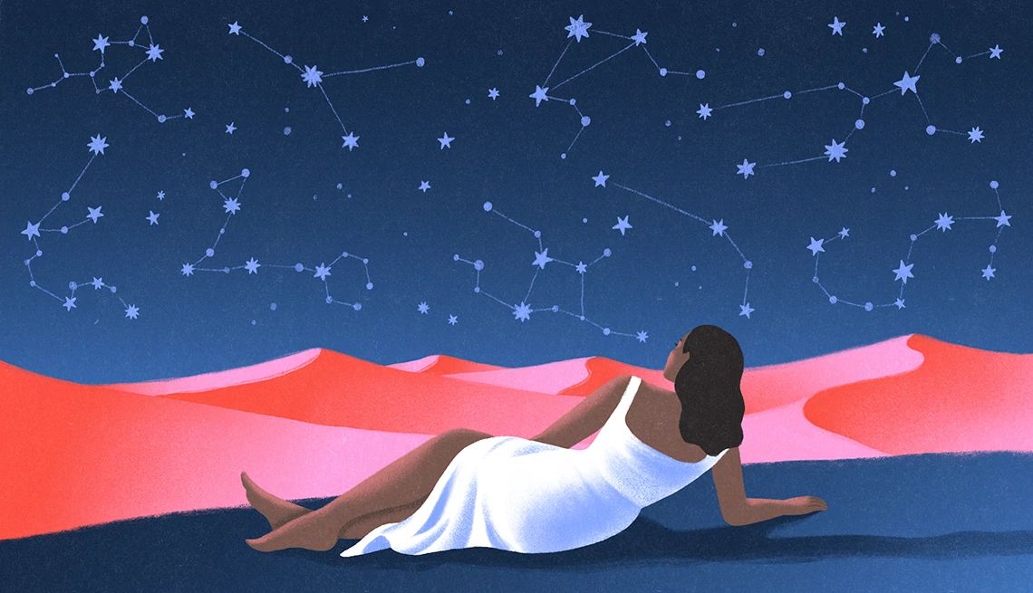 Why We Believe In Astrology a woman looks at the night sky filled with constellations