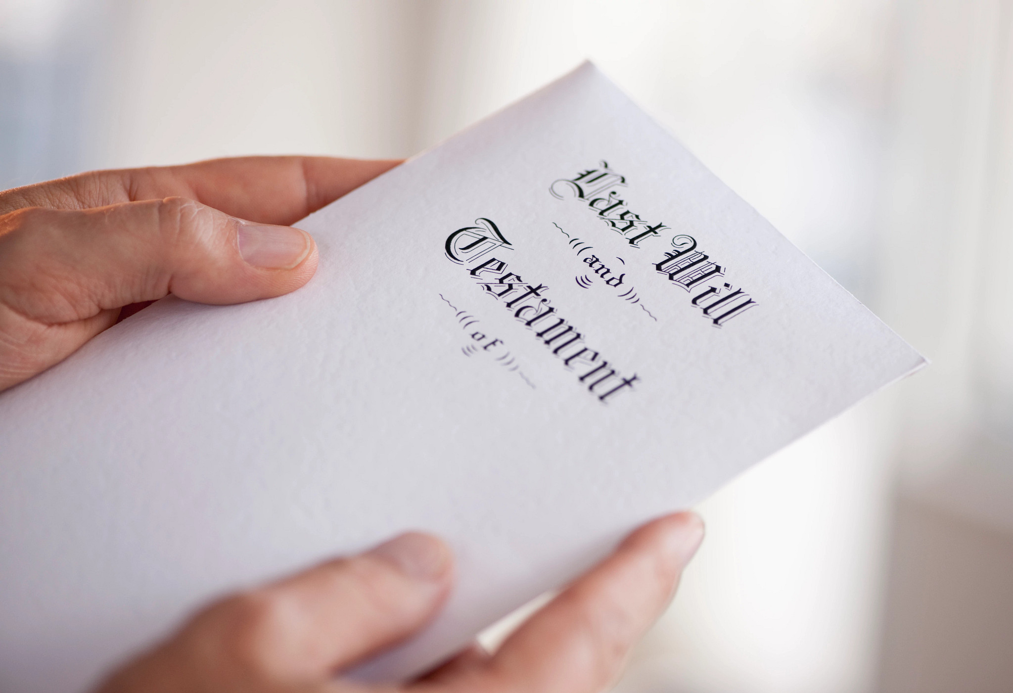 a photo shows a person holding a last will and testament