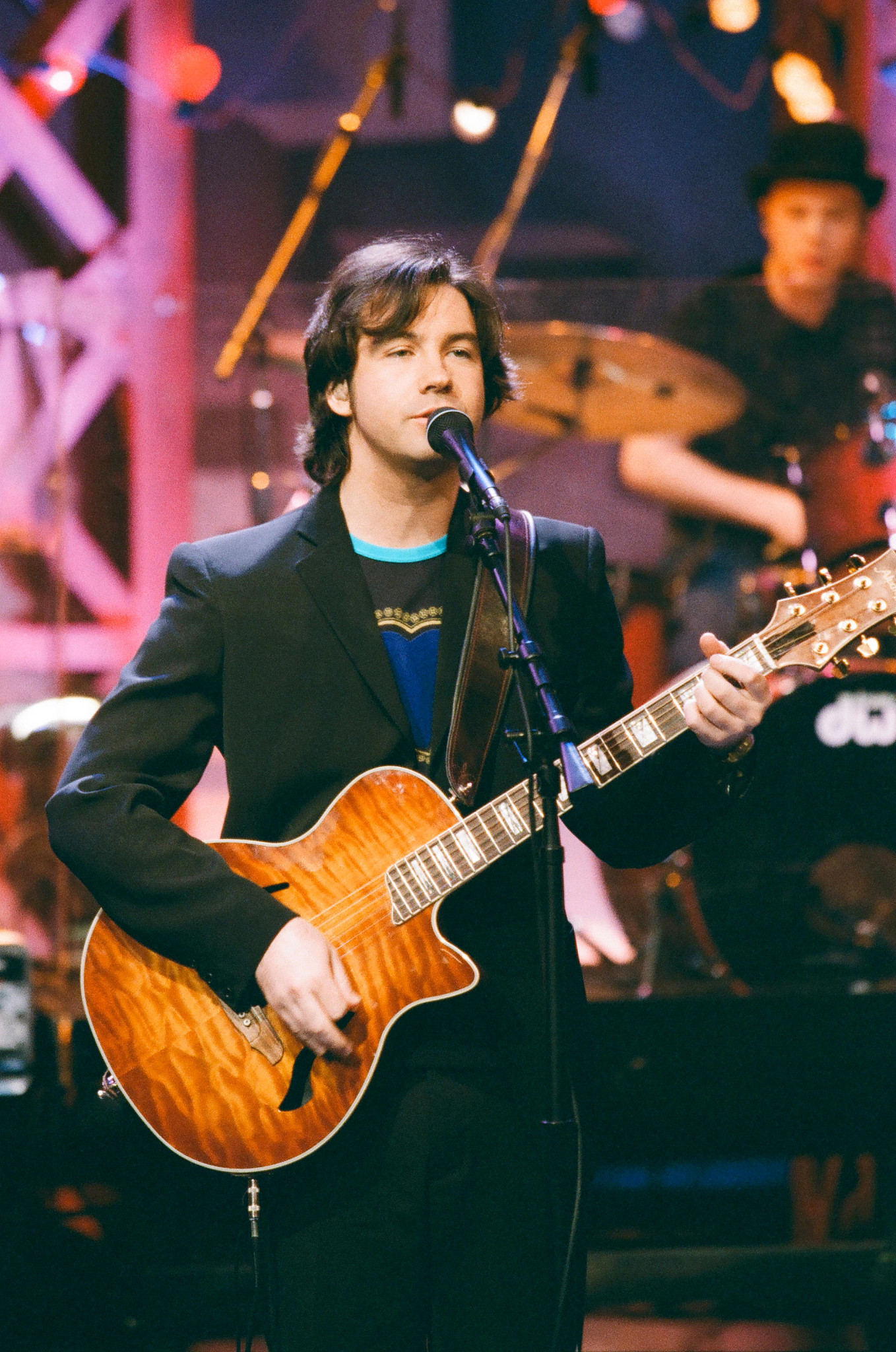 duncan sheik performing onstage with a guitar