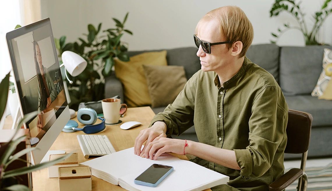 Social Security remote disability hearings high angle shot of man sitting at table and reading Braille book
