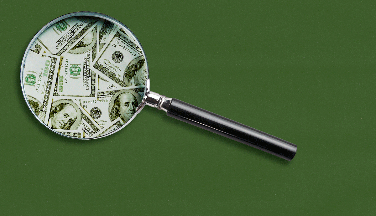 a magnifying glass searches a green background for money
