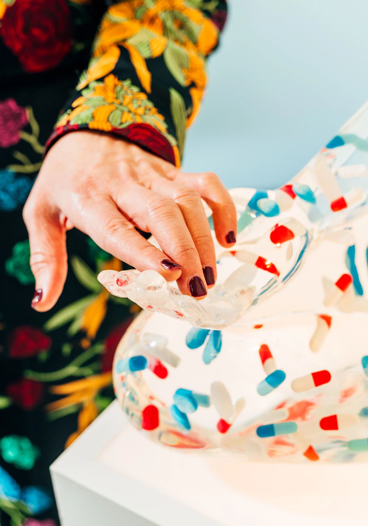 Jewel touches her sculpture "Chill"  Jewel's hand touching hand of sculpture