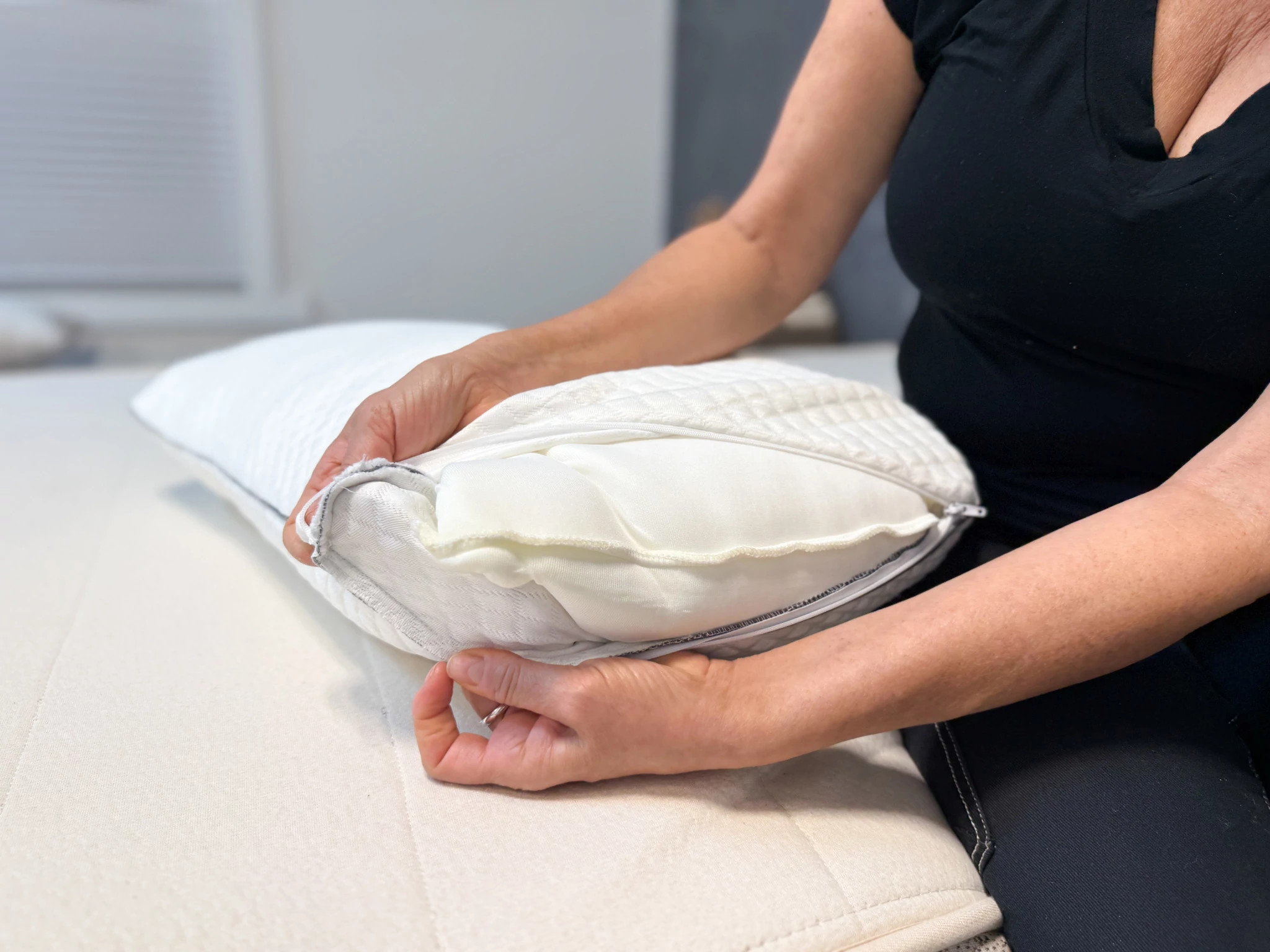 An older adult woman taking off the cover of the Nectar Serenity Cooling Pillow.