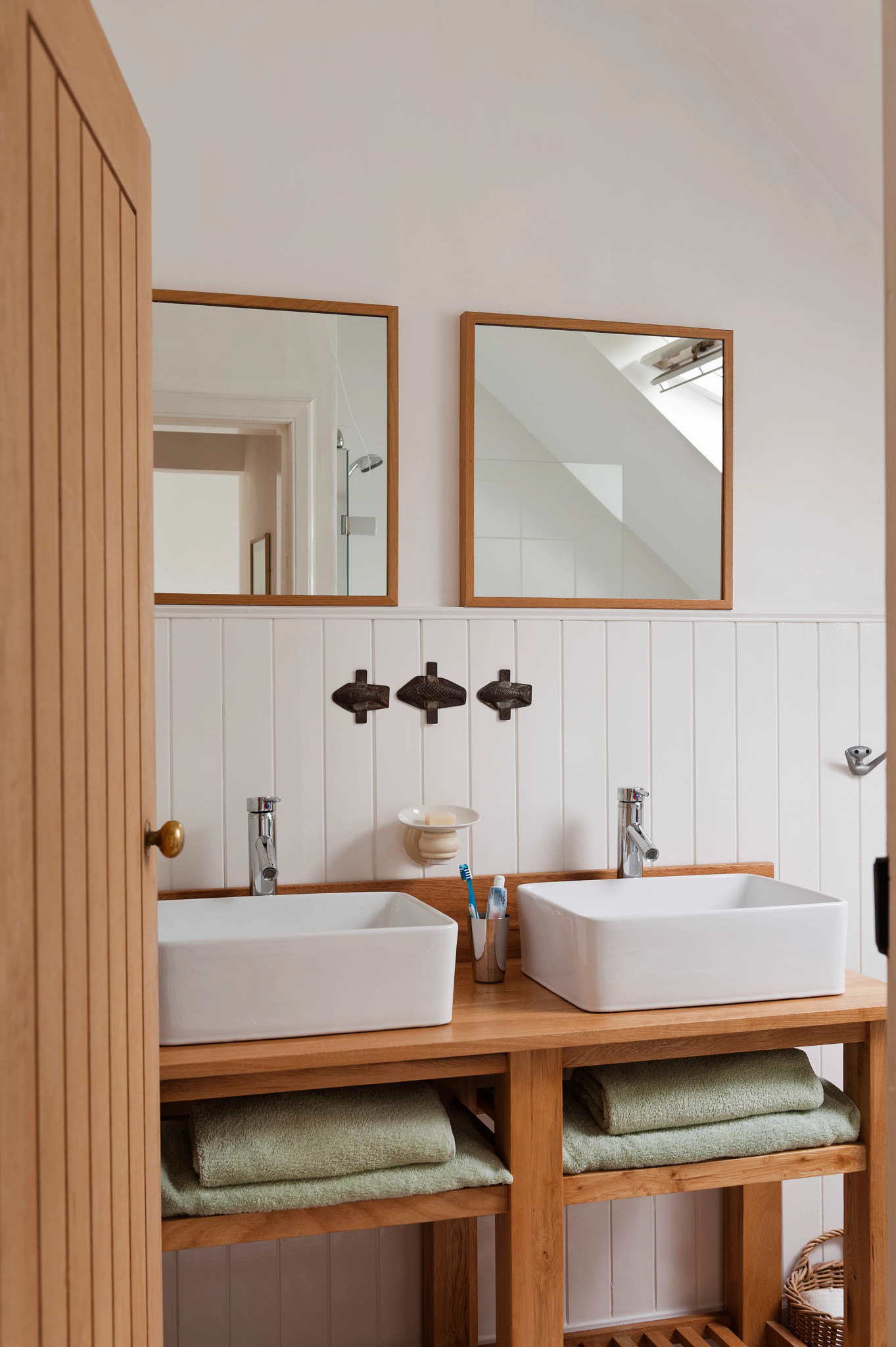 Double vanity unit with square mirrors and wood wall panelling
