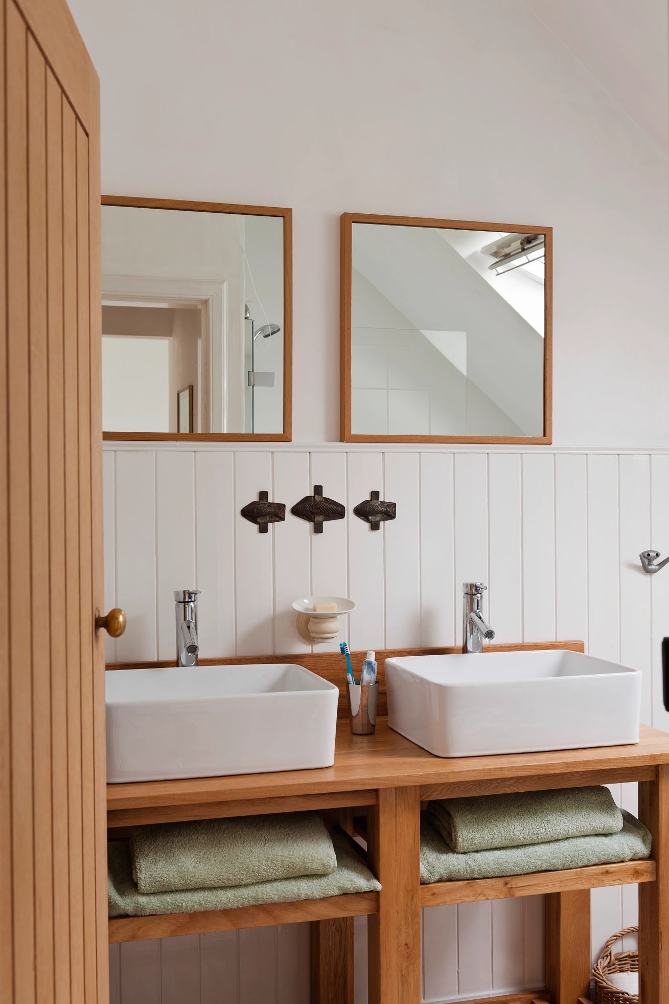 mirrors can help enlarge a bathroom Double vanity unit with square mirrors and wood wall panelling