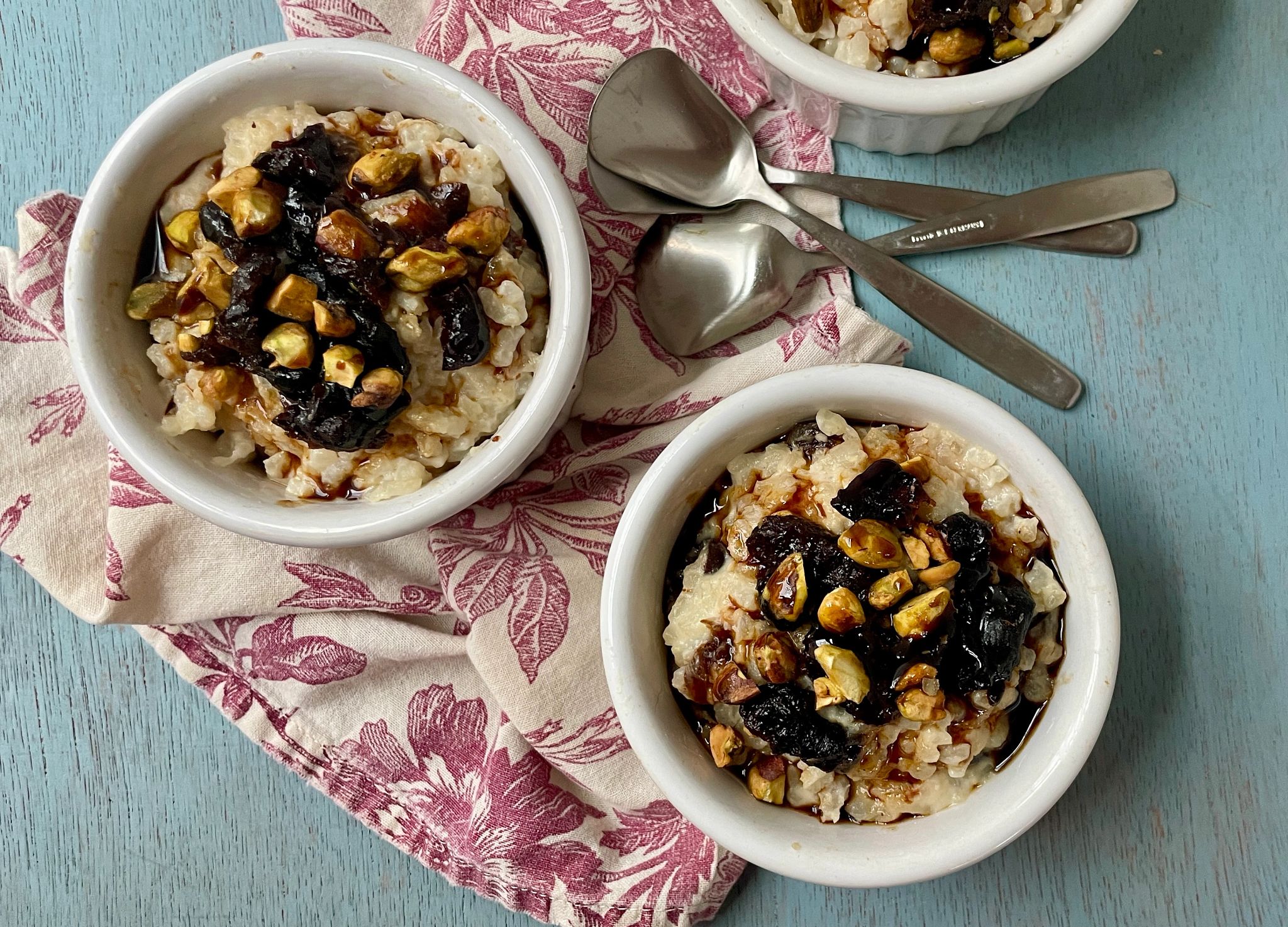 two bowls of prune-pomegranate risotto pudding on a table