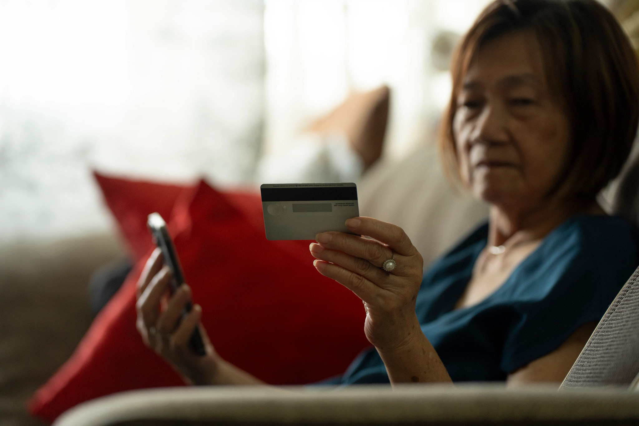 Elderly asian chinese woman being contacted by telephone scammer