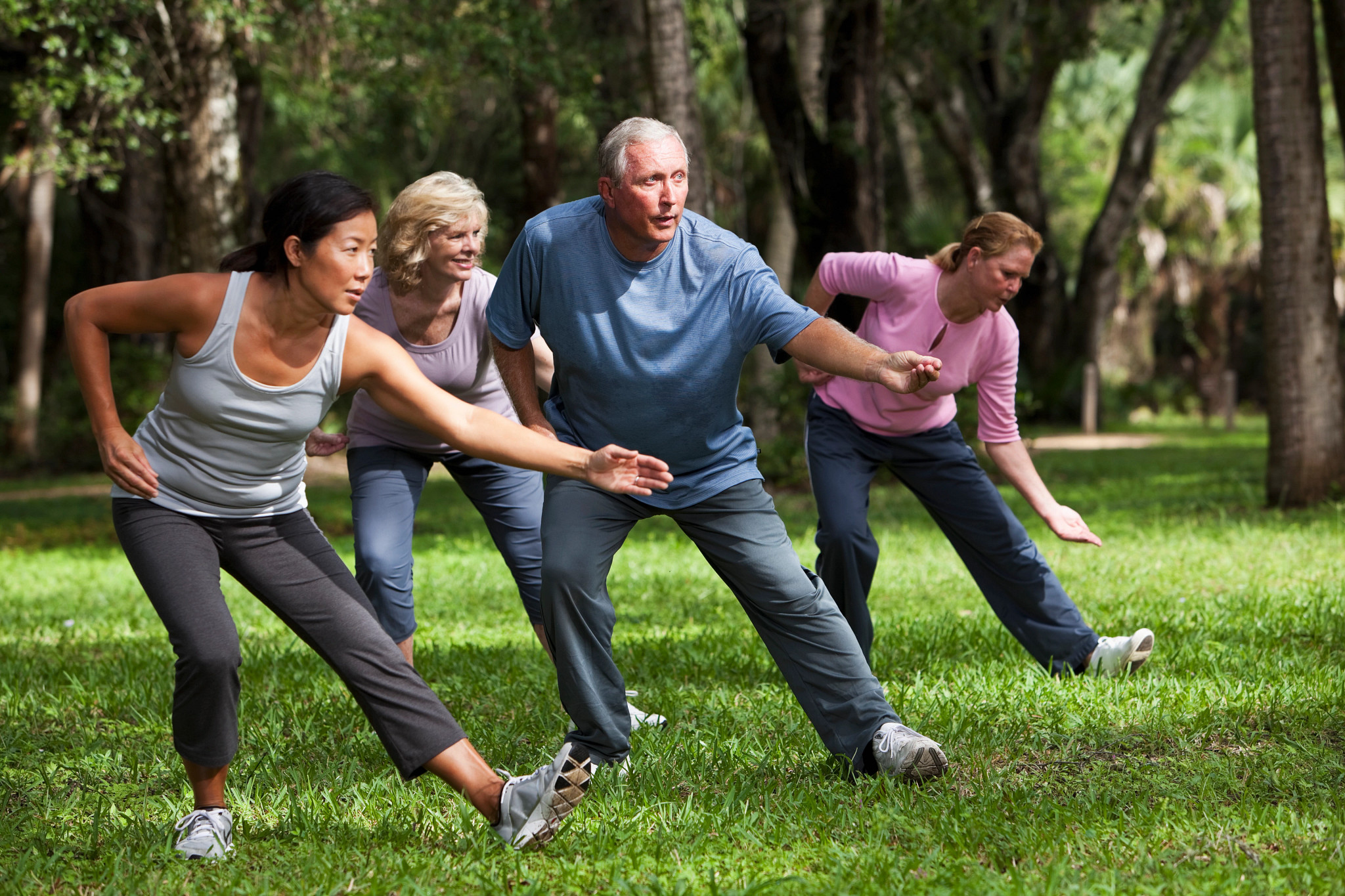 People perform Tai Chi in a park.