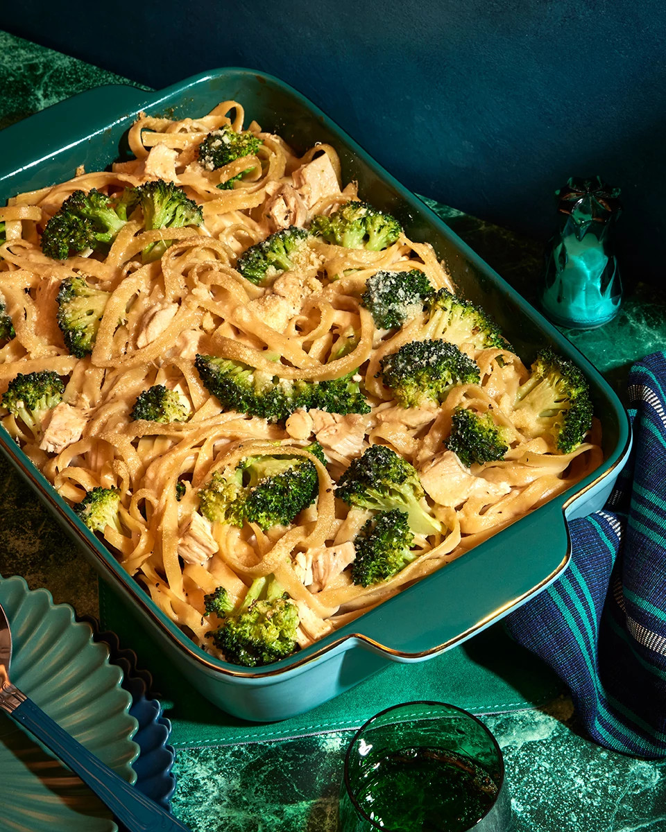 Creamy broccoli and noodle casserole baked in a green baking dish