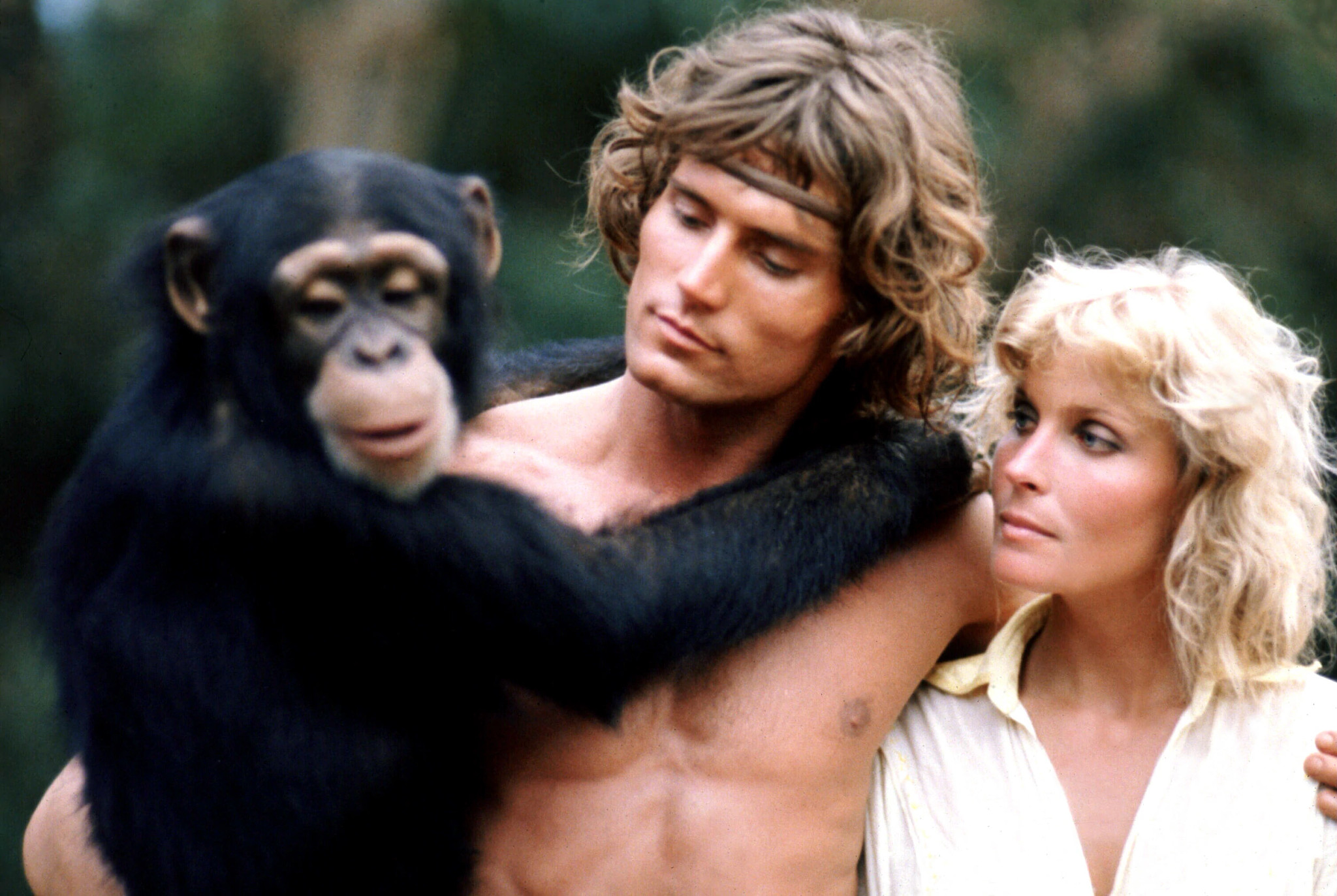 Miles O'Keeffe holding a monkey in his arm standing next to Bo Derek in the film Tarzan the Ape Man
