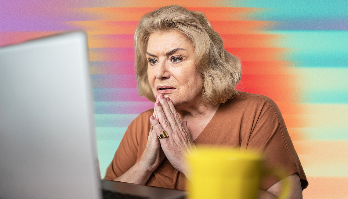 a woman looking at a computer with an anxious look on her face