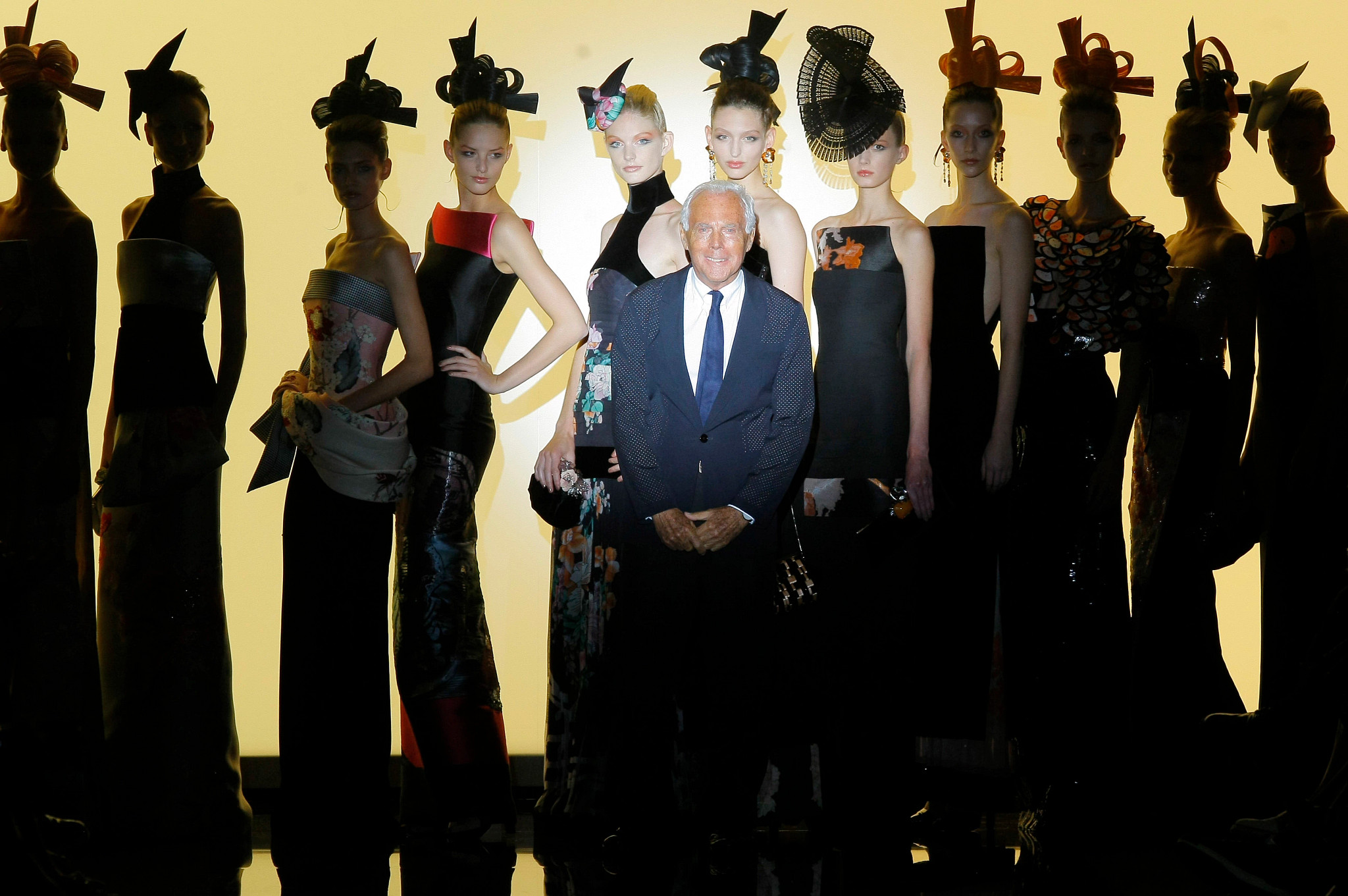 giorgio armani surrounded by fashion models on the runway