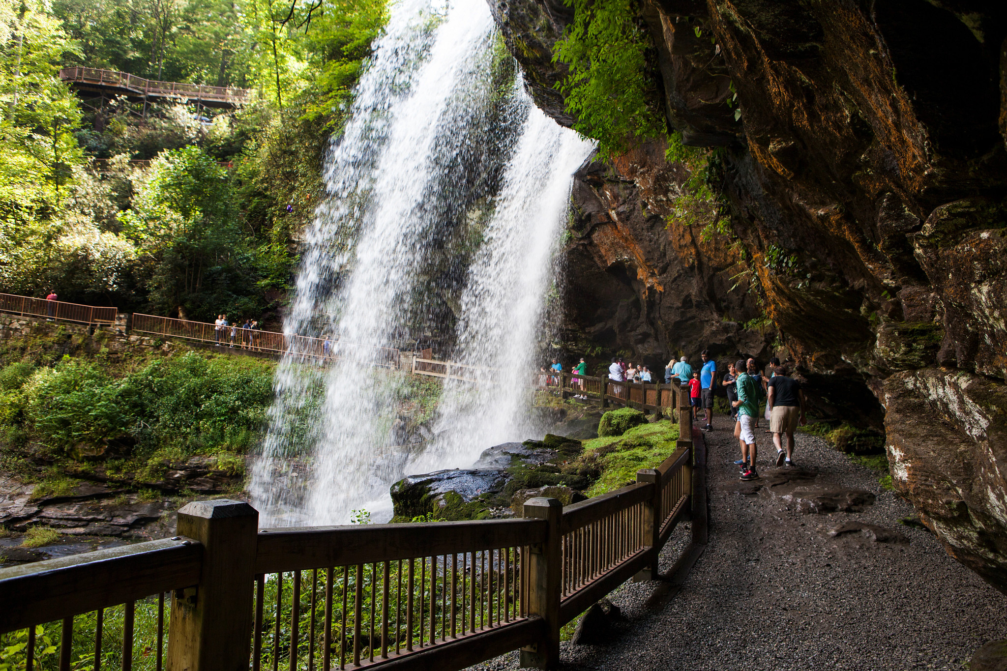 people enjoy a view from behind Dry Falls, in North Carolin