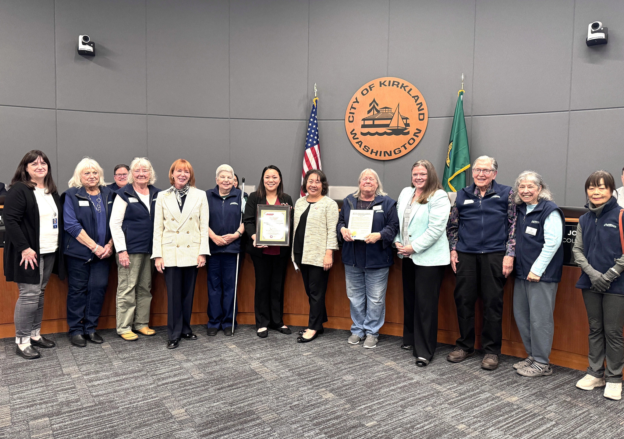 A large group of people posing for a photo together in front of the City of Kirkland, Washington