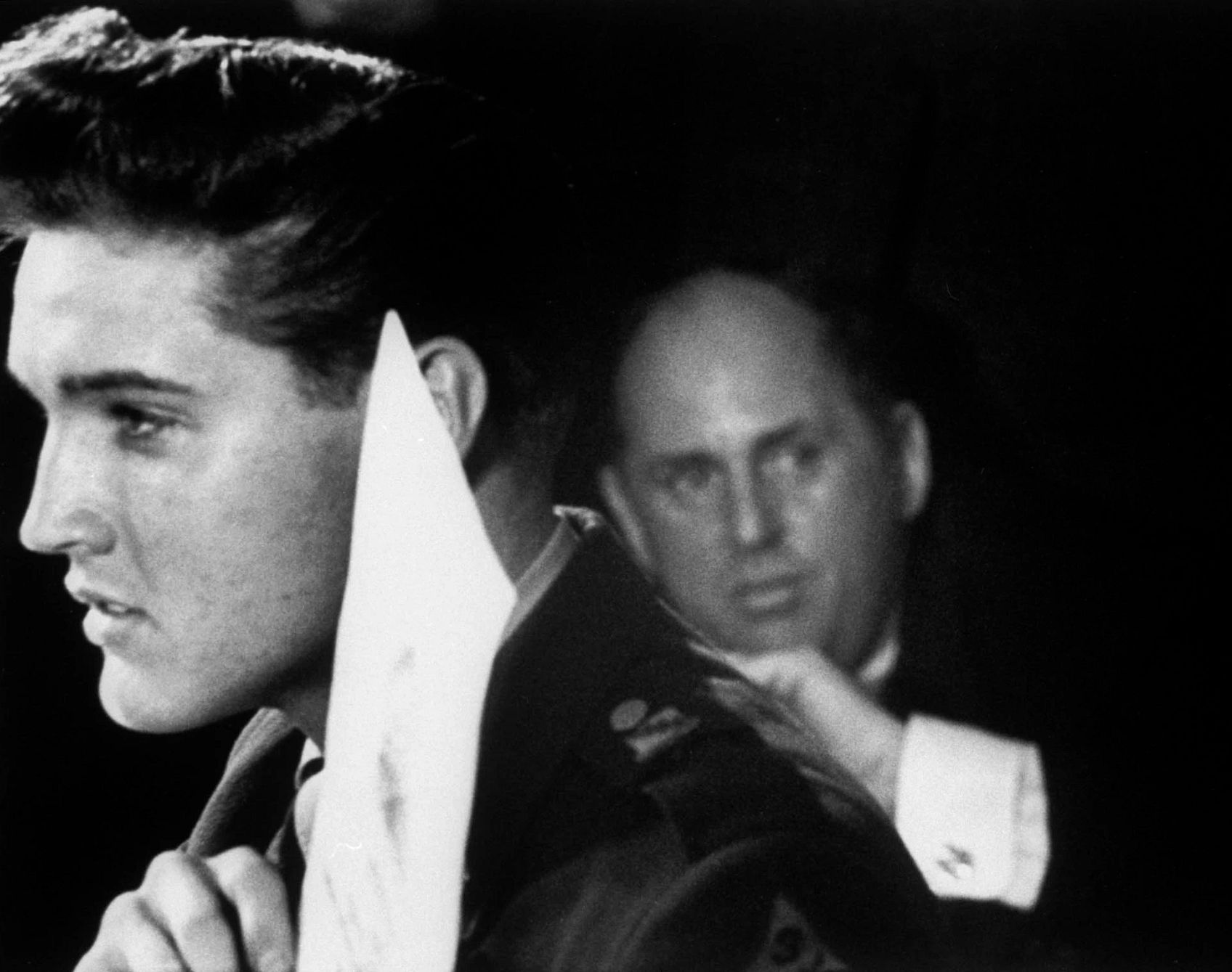 A New Look at the Man Who Managed Elvis colonel tom parker standing behind elvis presley