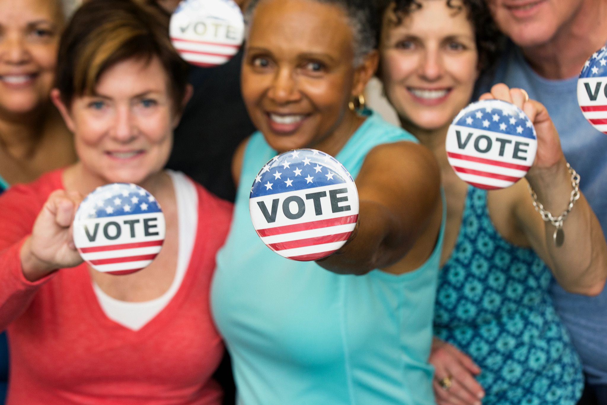 people holding vote buttons