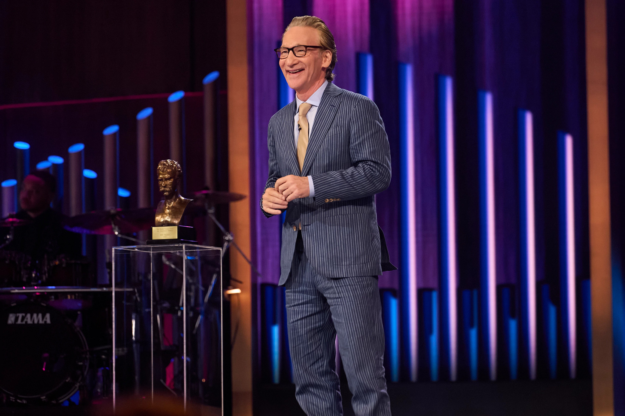 bill maher smiling onstage during the mark twain prize ceremony