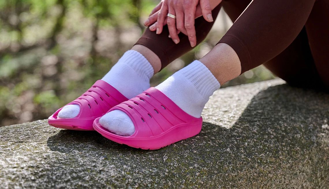 Oka Recovery a person wearing fuschia shoes sitting on a rock outside