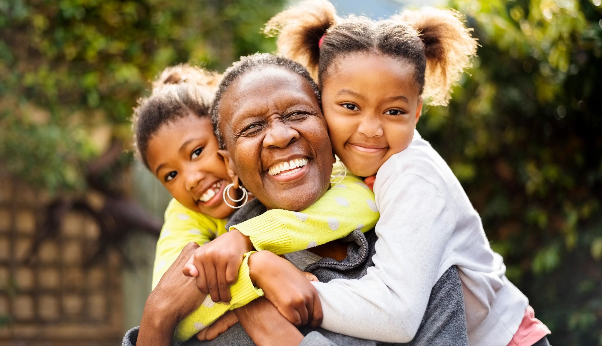 An African American woman smiling with her two young grandchildren. An African American woman smiling with her two young grandchildren.