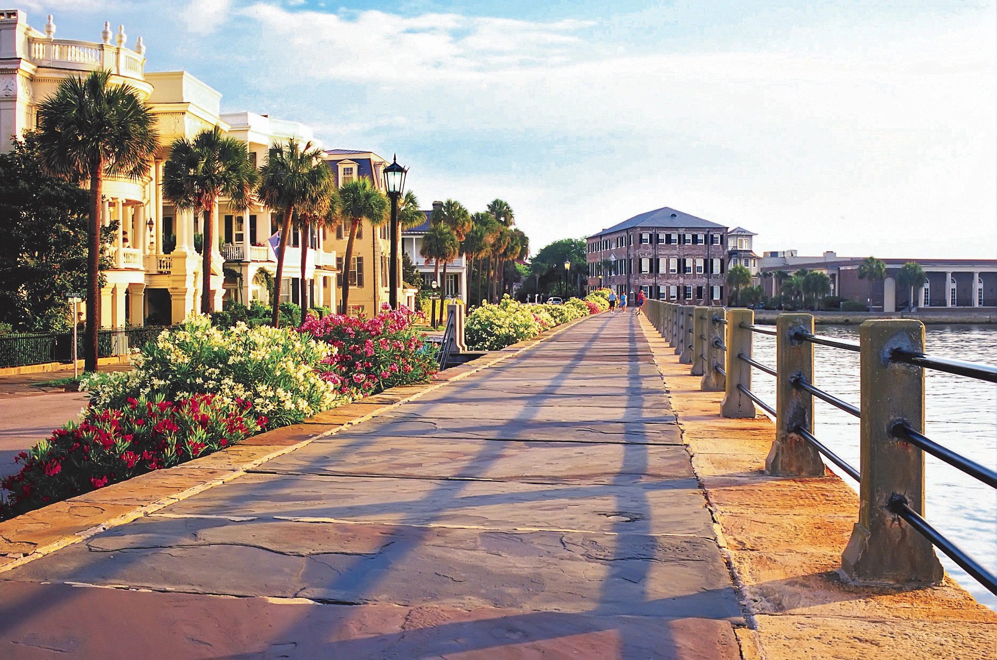 a walking path situated between the water and houses in Charleston, SC