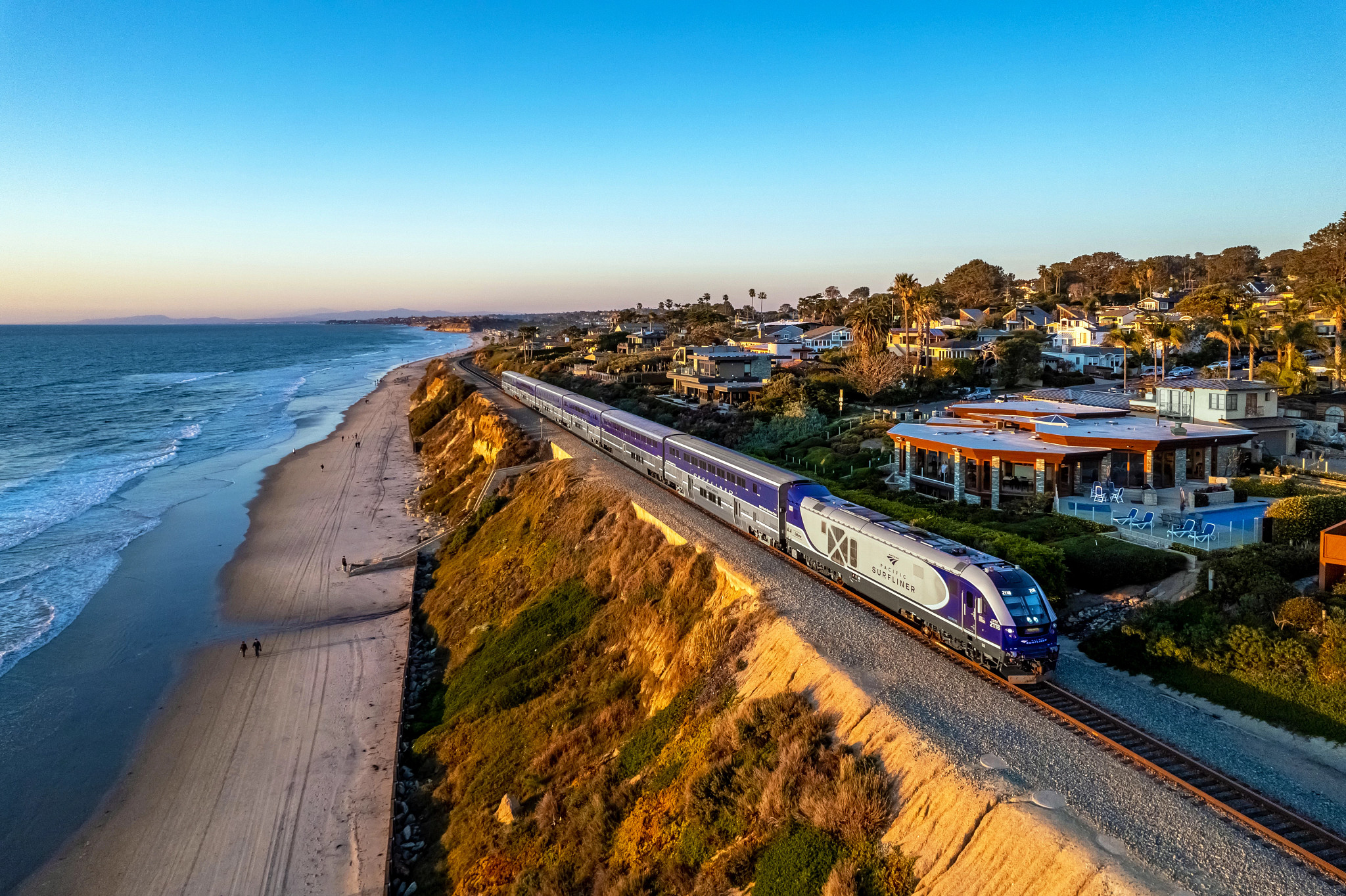 a train traveling on tracks near a shoreline