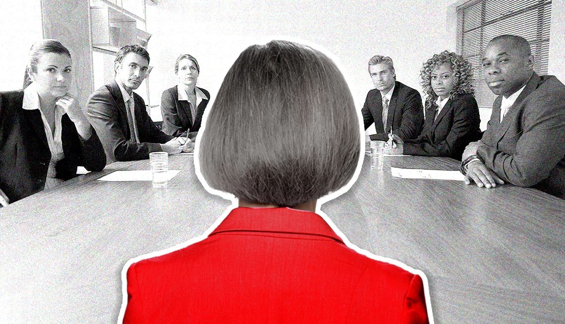 una mujer con una chaqueta roja se enfrenta a una mesa llena de ejecutivos