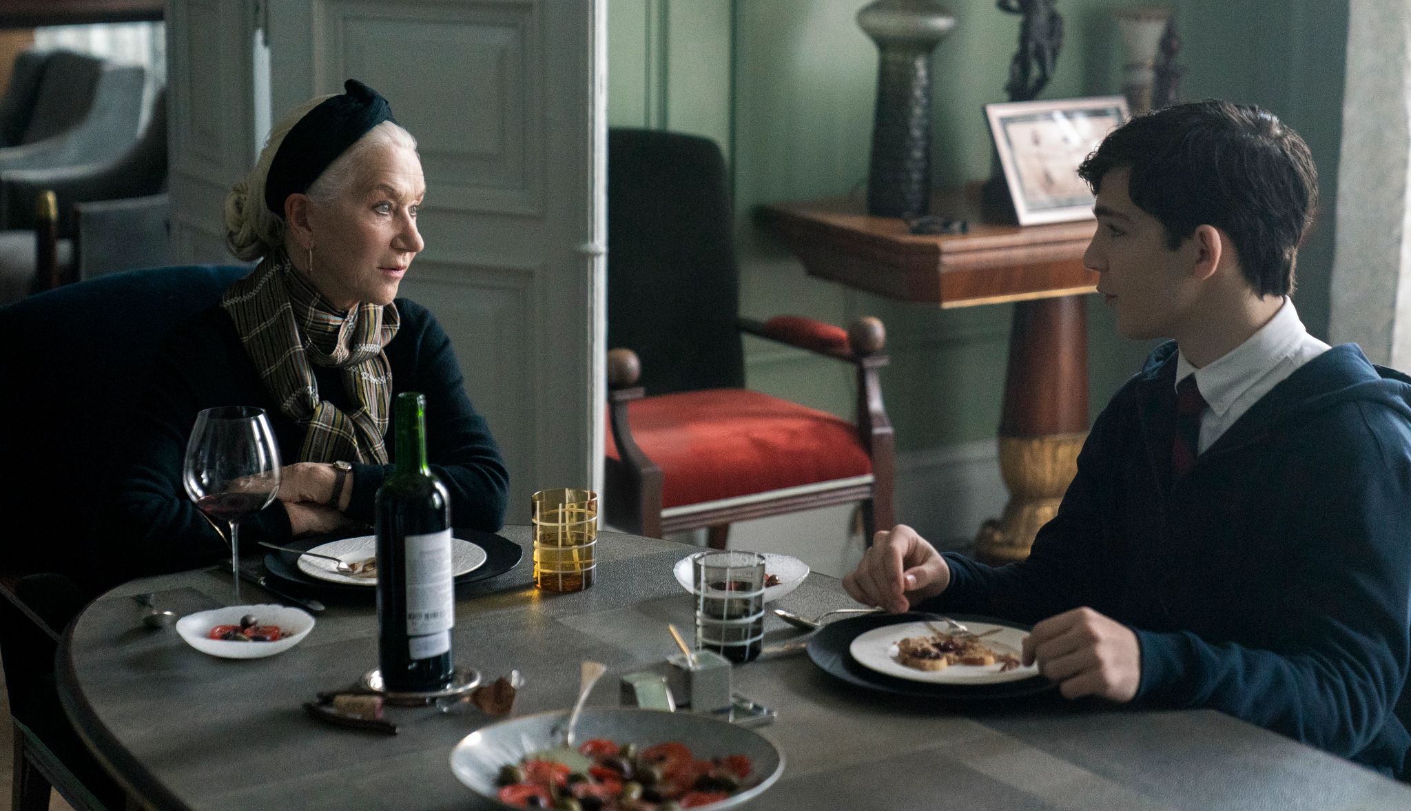 Helen Mirren starred in 'White Bird' Helen Mirren as Grandmère and Bryce Gheisar as Julian sitting at a table with food and wine in front of them in a still from White Bird A Wonder Story