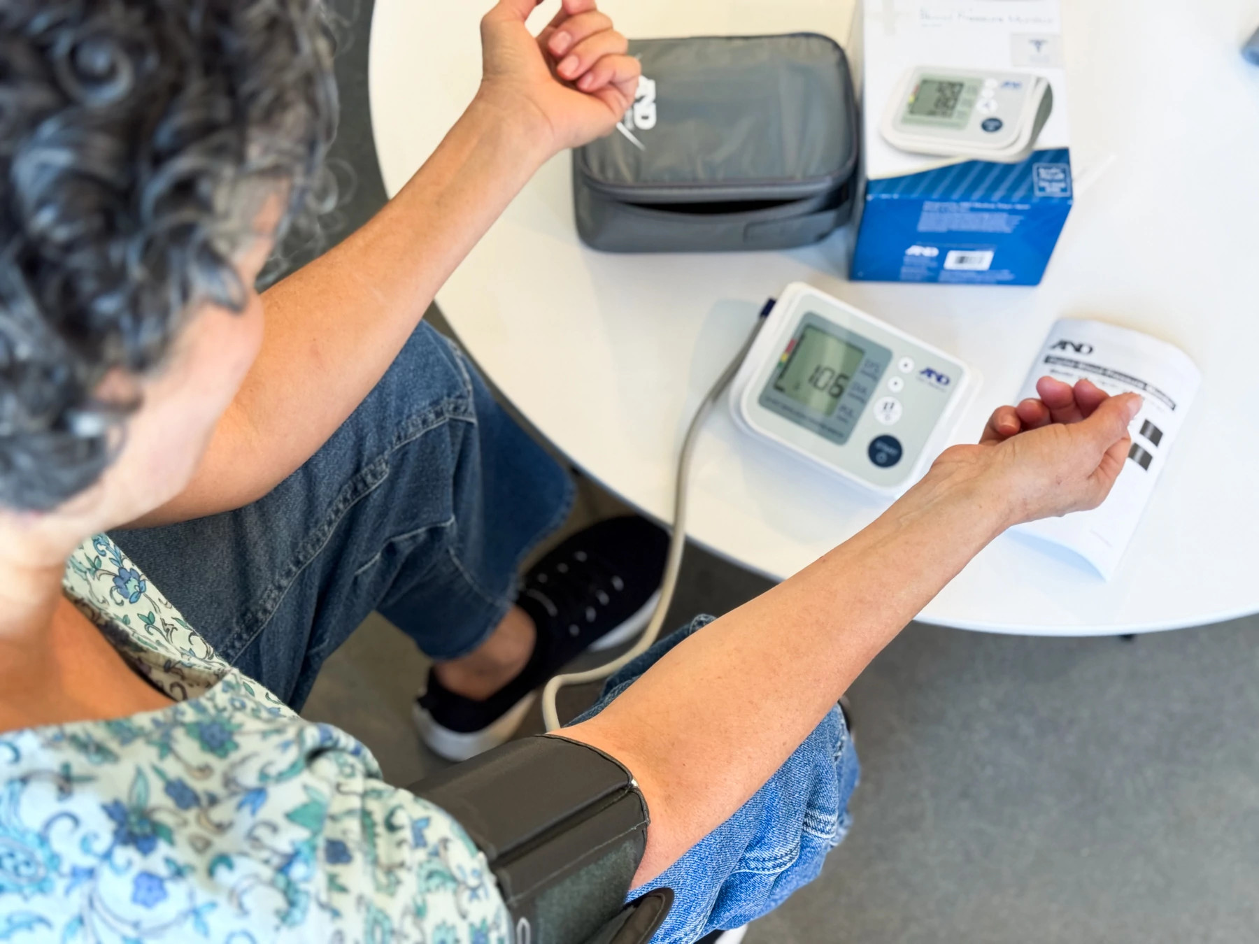 A woman taking a blood pressure reading with the A&D Medical Premium Multi-User blood pressure monitor.