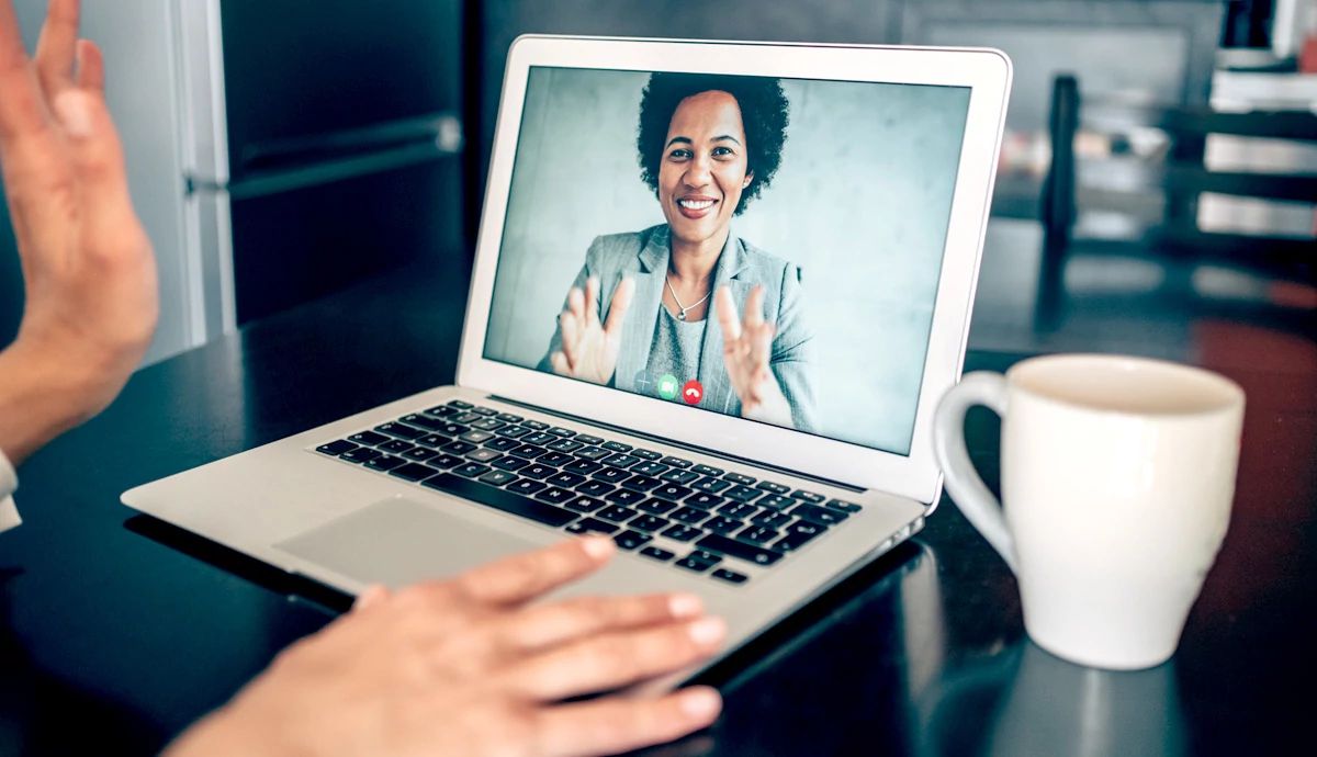 Close up  of woman on laptop screen smiling during virtual job interview
