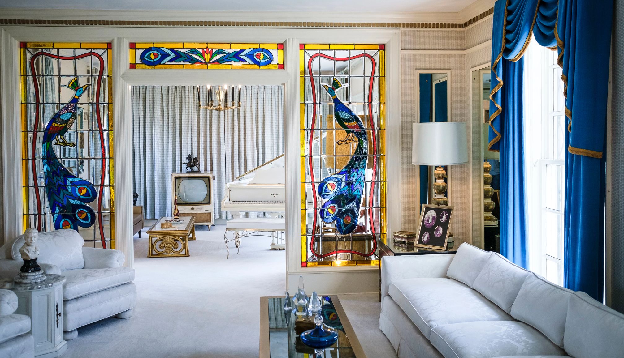 Colonial Revival mansion The living room of this Colonial Revival mansion is subdued with white furniture and stained-glass peacock panels