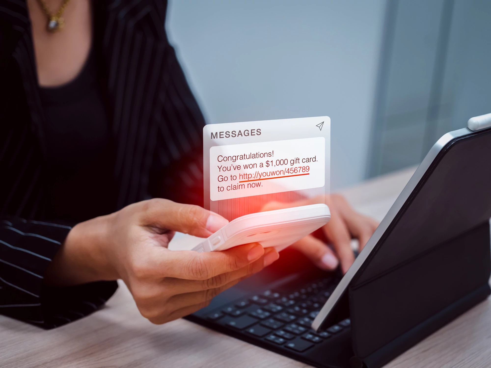 phishing text message showing while business woman use mobile phone and working with tablet computer