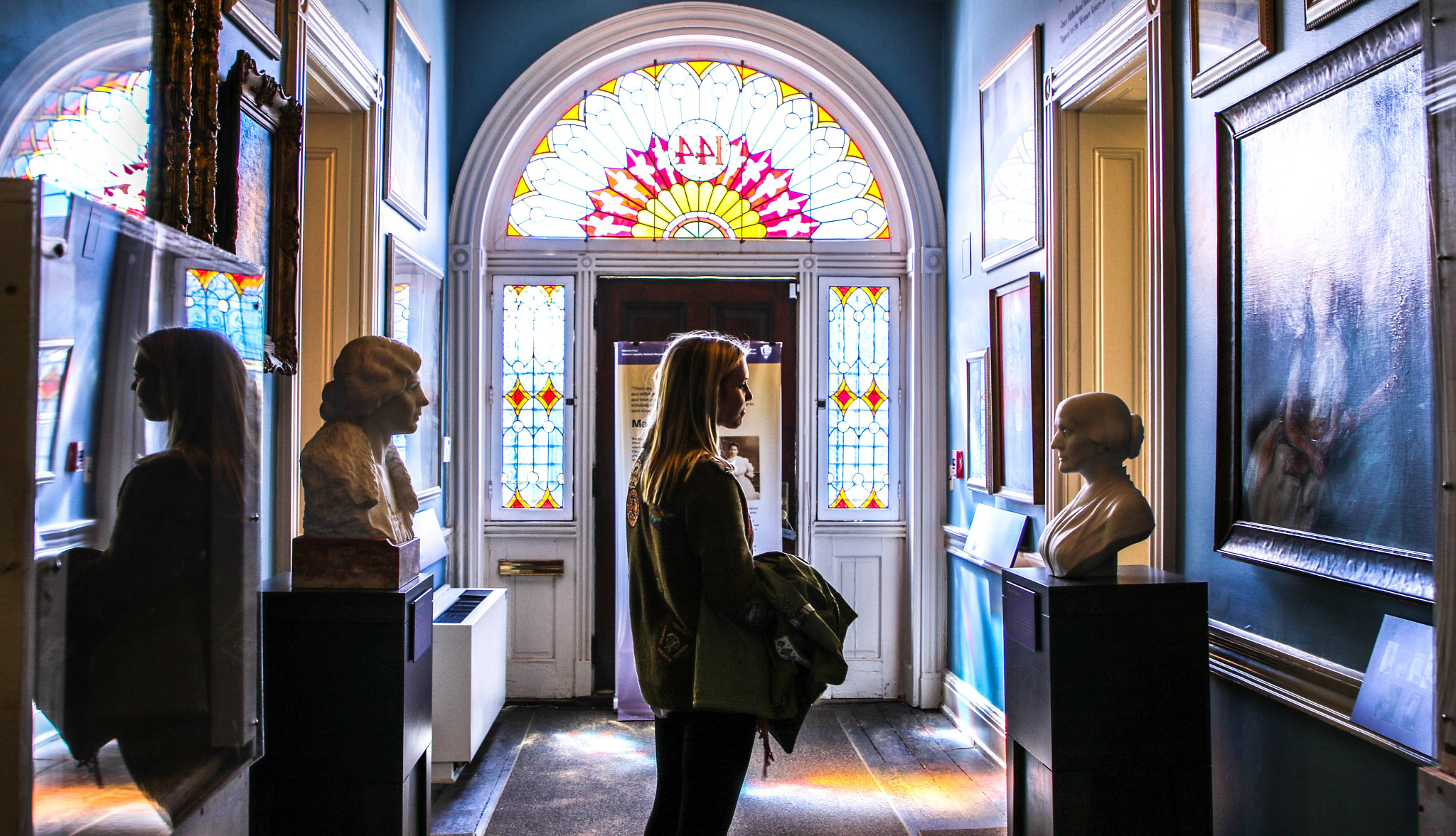 a visitor looks at busts in a museum room
