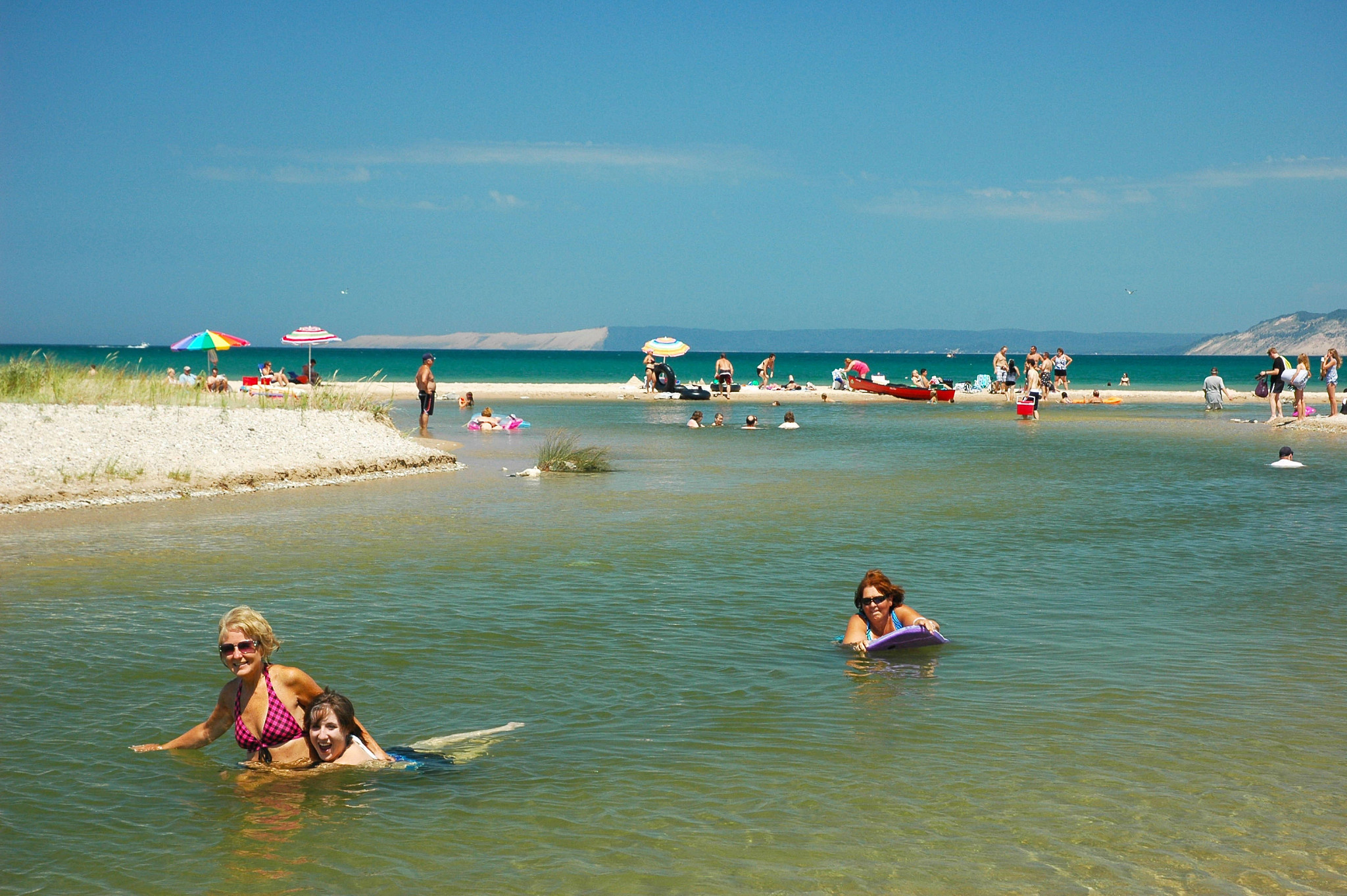 people playing in shallow water at a beach