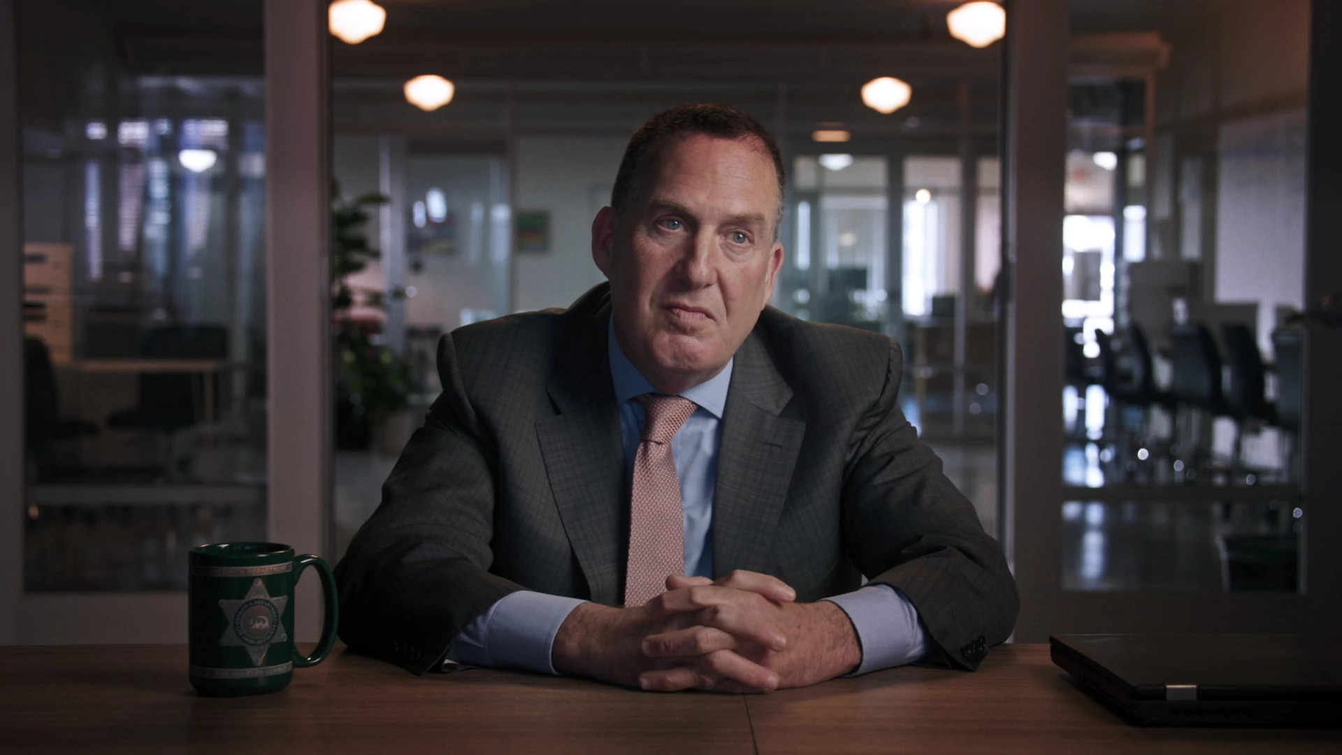 Los Angeles County Deputy District Attorney John Lewin sitting at a table for interview
