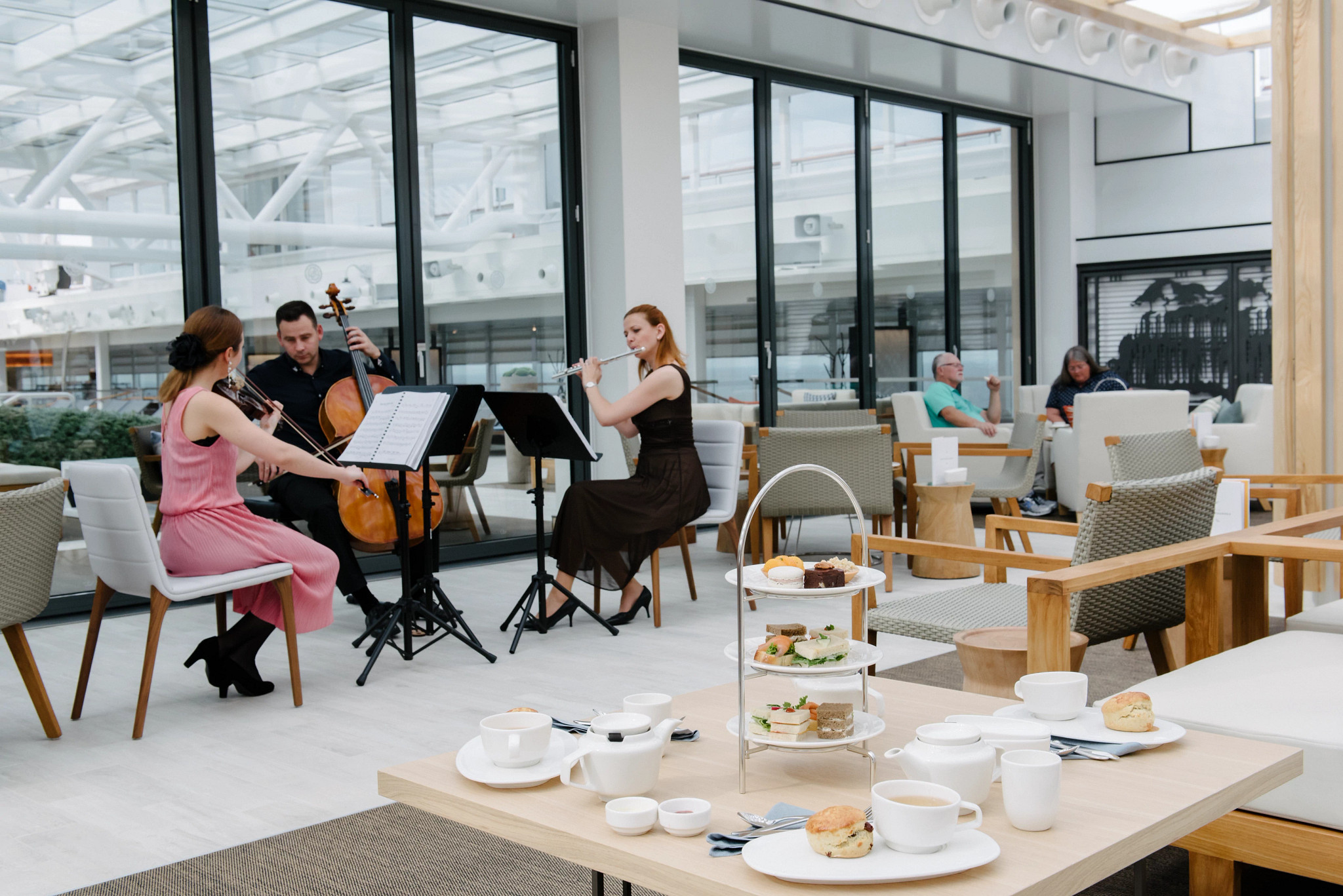 tea and desserts on a table with musicians playing in the background