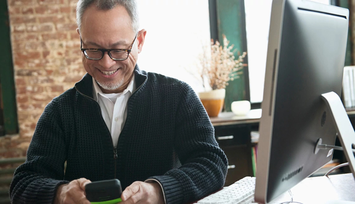 Man smiling at cell phone