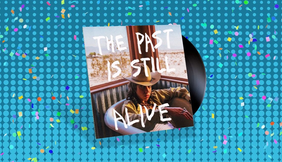 Hurray for the Riff Raff's “The Past Is Still Alive” Album cover with record sticking out of it and the words the past is still alive and person in cowboy hat on cover; blue background with confetti on it