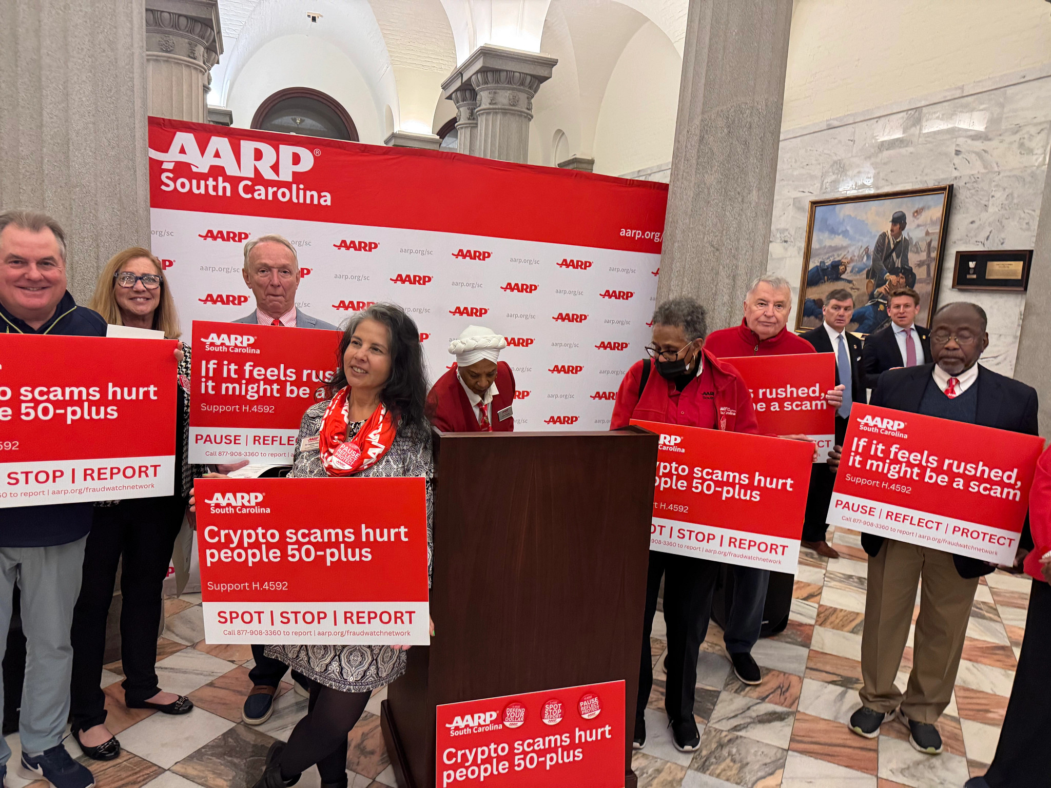 Photo of AARP SC Executive Council members standing at the press conference holding signs